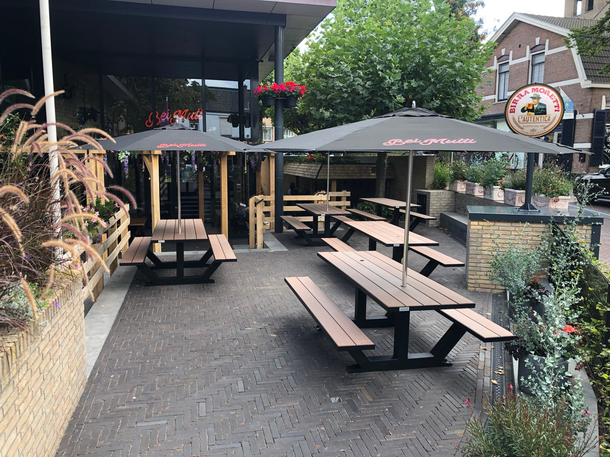 Zwarte picknicktafels Anker onder de pergola van restaurant Bei Mutti, Oosterbeek